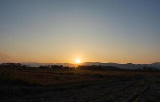 pôr do sol céu com outono Fazenda. campo panorama foto