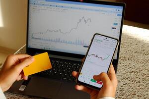 a investidor quem compra moedas com uma crédito cartão. bitcoin gráfico em computador dentro fundo foto