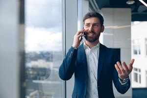 retrato do inspirado homem usando Móvel telefone e fazer uma ligar dele o negócio parceiro às escritório foto