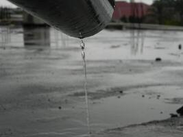 foto do água da chuva a partir de tubos e pavimentos em a topo chão do a urbano construção