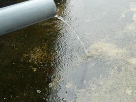 foto do água da chuva a partir de tubos e pavimentos em a topo chão do a urbano construção
