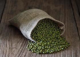 grama verde ou feijão mungo em sacos na mesa foto