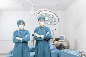 retrato de dois cirurgiões em pé na sala de cirurgia. cirurgia e conceito de emergência foto
