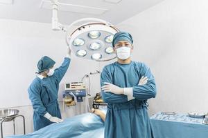 retrato de dois cirurgiões em pé na sala de cirurgia. cirurgia e conceito de emergência foto