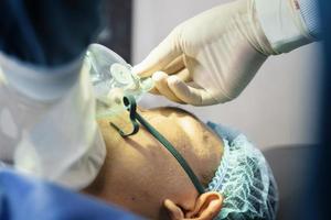 o cirurgião assistente colocou o paciente em uma máscara de ventilador de oxigênio em preparação para a cirurgia.