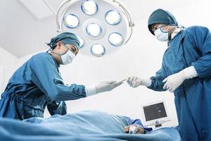assistente distribui instrumentos aos cirurgiões durante a operação. cirurgia e conceito de emergência