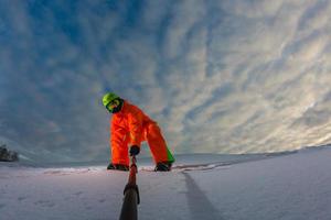 snowboarder com a prancha de snowboard fazendo uma selfie foto