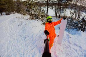 snowboarder com a prancha de snowboard fazendo uma selfie foto