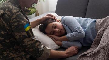 soldado dentro ucraniano militares uniforme se beijando dele filha enquanto ela dormindo em sofá às lar. família reunião. foto