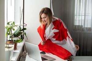 mulher mãos e bandeira do Canadá em computador, computador portátil teclado foto