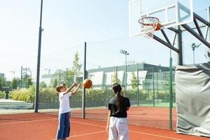 conceito do Esportes, hobbies e saudável estilo de vida. jovem pessoas jogando basquetebol em Parque infantil ao ar livre foto