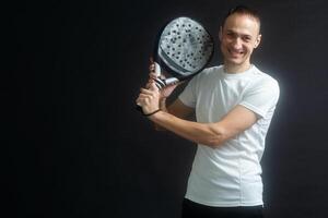 lindo homem jogando remo tênis, raquete dentro mão concentrado olhar. jovem desportivo Garoto pronto para a corresponder. focado padel atleta pronto para receber a bola. esporte, saúde, juventude e lazer conceito foto