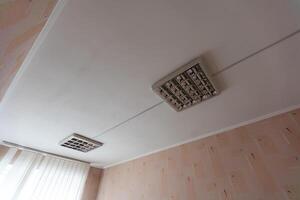 textura ou fundo, papel de parede do uma branco teto com luz do dia lâmpadas dentro uma público instituição durante a dia. foto