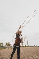 bonita chinês vaqueira jogando a laço dentro uma cavalo Pomar, pasto foto