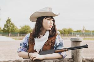 retrato do uma lindo chinês fêmea vaqueira tiroteio com uma arma foto