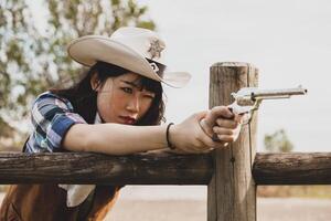 retrato do uma lindo chinês fêmea vaqueira tiroteio com uma arma foto