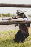 retrato do uma lindo chinês fêmea vaqueira tiroteio com uma arma foto