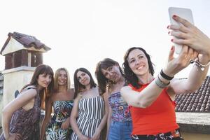 grupo do fêmea amigos levando uma selfie com smarthphone foto