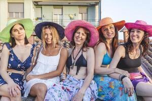 grupo do fêmea amigos em período de férias sentado em a telhados foto