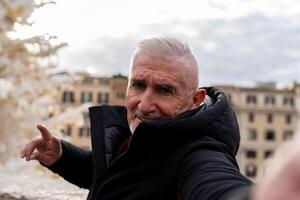 feliz maduro homem turista levando uma selfie dentro frente do praça di spagna dentro Roma foto