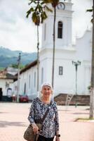 Senior adulto mulher às a central quadrado dentro a cidade do guaduas localizado dentro a departamento do cundinamarca dentro Colômbia. Senior estilo de vida. Senior viagem conceito. foto