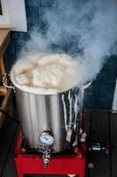 fervura ou uma pausa quente de fermentação caseira e muita espuma de proteína na chaleira de fervura aquecendo foto