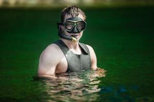 engraçado jovem adulto snorkeling em um rio foto