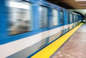 trem de metrô em movimento e borrão de movimento com uma plataforma de metrô vazia. foto