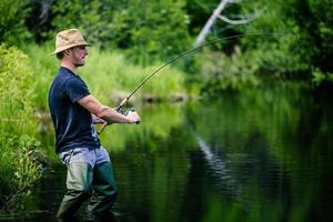 jovem pescador pegando um grande peixe foto