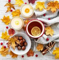 outono plano deitado com uma xícara de chá e folhas foto