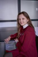 retrato do uma jovem mulher dentro uma vermelho escritório terno foto