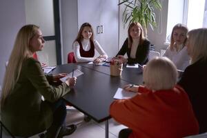 uma equipe do Sete mulheres é segurando uma encontro dentro a escritório foto