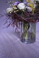 Páscoa guirlanda, ninho do salgueiro galhos e flores decorado com ovos e vidro teste tubos dentro uma transparente vaso foto
