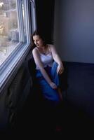 jovem Adolescência menina brigando cérebro Câncer dentro uma estúdio foto tiro sentado em uma cadeira de a janela