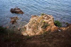 uma Rocha dentro a Mediterrâneo mar é coberto com argila foto