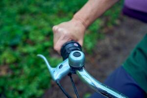 idosos mulher caminhando dentro Primavera floresta com bicicleta e ioga esteira foto