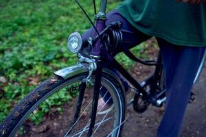 idosos mulher caminhando dentro Primavera floresta com bicicleta e ioga esteira foto