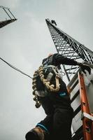 trabalhador de telecomunicações escalando torre de antena foto