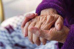 fechar-se do enrugado mãos do a idosos mulher. conceito do envelhecido pessoas e cuidados de saúde foto