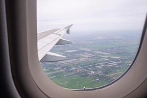 aéreo Visão do terras e nuvens visto através a avião janela foto
