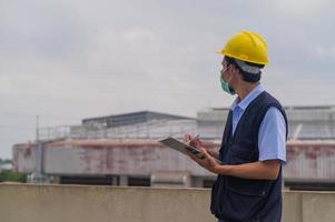 os engenheiros tomam nota das inspeções da planta industrial. foto