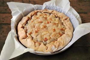 torta salgada inteira com bacon recém assado em uma panela foto