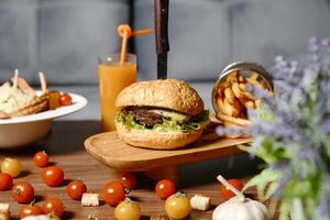 suculento hamburguer e crocantes fritas em de madeira mesa foto