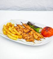 branco prato com frango e francês fritas foto