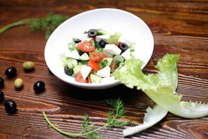 branco tigela preenchidas com salada em de madeira mesa foto