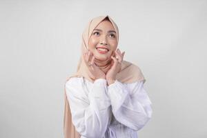 retrato do lindo ásia muçulmano mulher com natural Maquiagem vestindo branco vestir e hijab posando em branco fundo dentro estúdio. facial pele Cuidado, fêmea beleza conceito foto