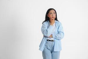 uma pensativo ásia mulher vestindo azul camisa é imaginando dela pensamentos, isolado de branco fundo. foto