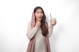 sorridente ásia muçulmano mulher dentro lenço de cabeça véu hijab segurando café dentro uma plástico copo esperando para iftar para bebida. Ramadã conceito foto