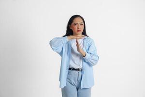 ásia mulher vestindo casual azul camisa fazendo Tempo Fora gesto com mãos e sério face, isolado branco fundo foto
