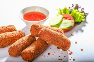 queijo dedos com molho e salada servido dentro uma prato lado Visão em cinzento fundo foto